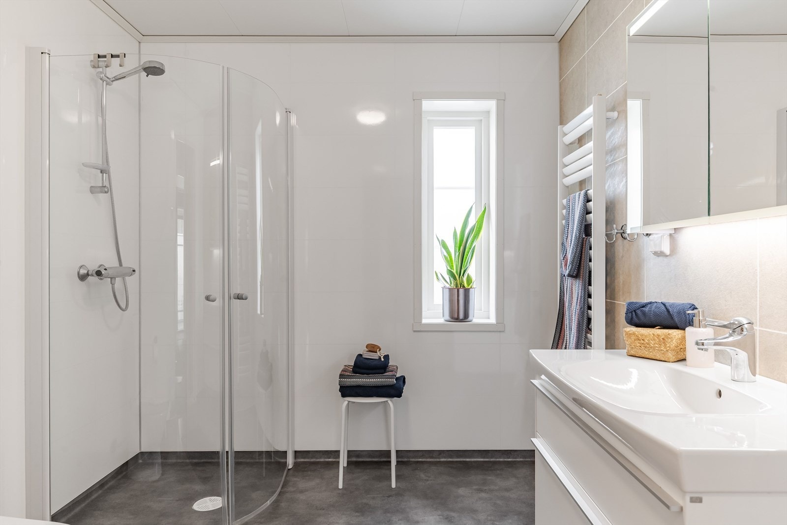 Lyst og moderne baderom 1 fra byggeåret 2022. Baderommet har våtromsbelegg på gulv, lyse våtromsplater på veggene og avtrekk via balansert ventilasjon. Galleribilde