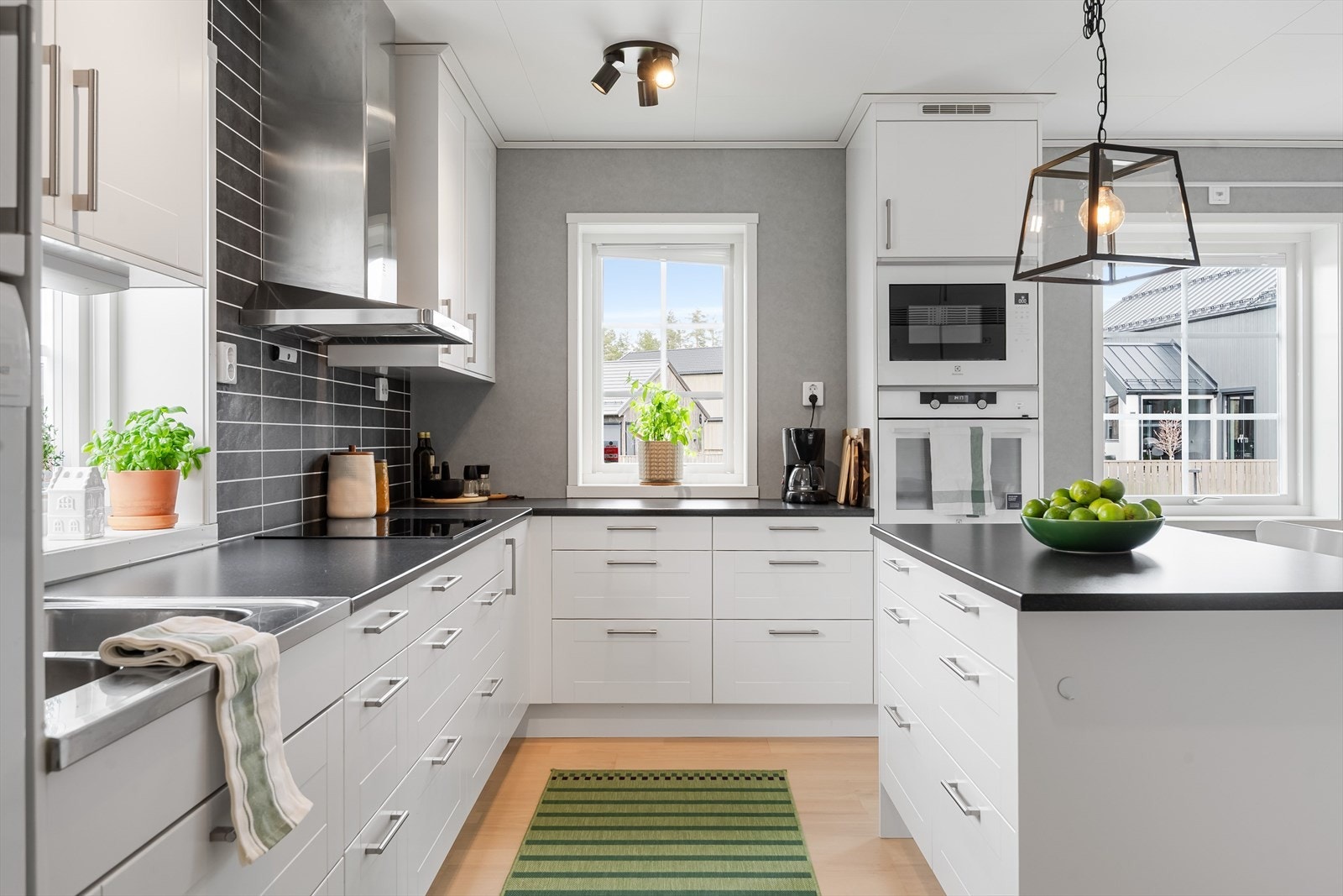 Innredningen har hvite glatte fronter og laminert benkeplate med nedfelt oppvaskkum. Kjøkkenet er utstyrt med medfølgende integrerte hvitevarer som nedfelt platetopp, samt stekeovn og mikrobølgeovn i høyskap. Galleribilde