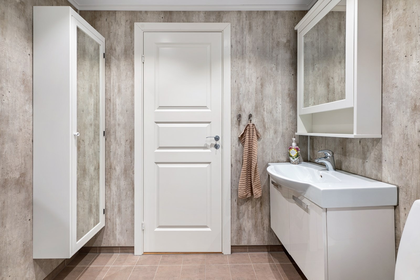 Badet har flislagt gulv med varmekabler og våtromspanel på vegger, i behagelige og moderne nyanser. Galleribilde