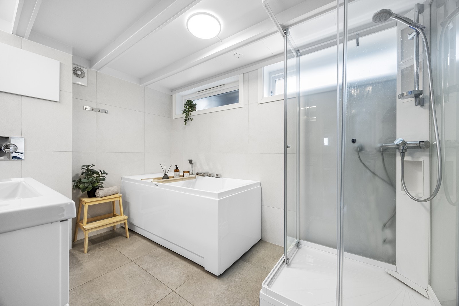 Lekkert, flislagt bad med varmekabler i gulv. Badet er innredet med både dusjkabinett og badekar. Galleribilde