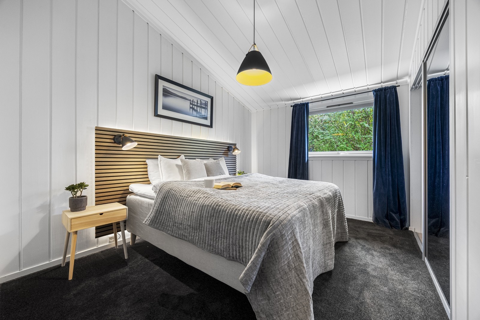 Soverom 1 med teppe på gulv, sengegavl med belysning og skyvedørsgaderobe. Galleribilde