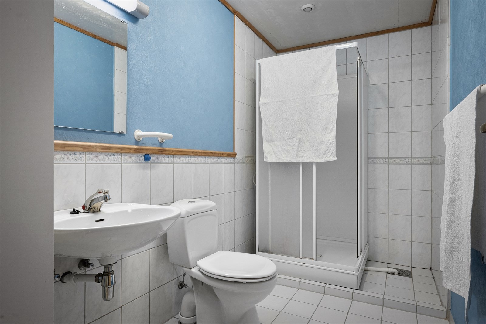 Bad med dusjkabinett, wc og vask. Enkelt og funksjonelt. Gir gode fasiliteter i kjelleren som en helhetlig etasje. Galleribilde