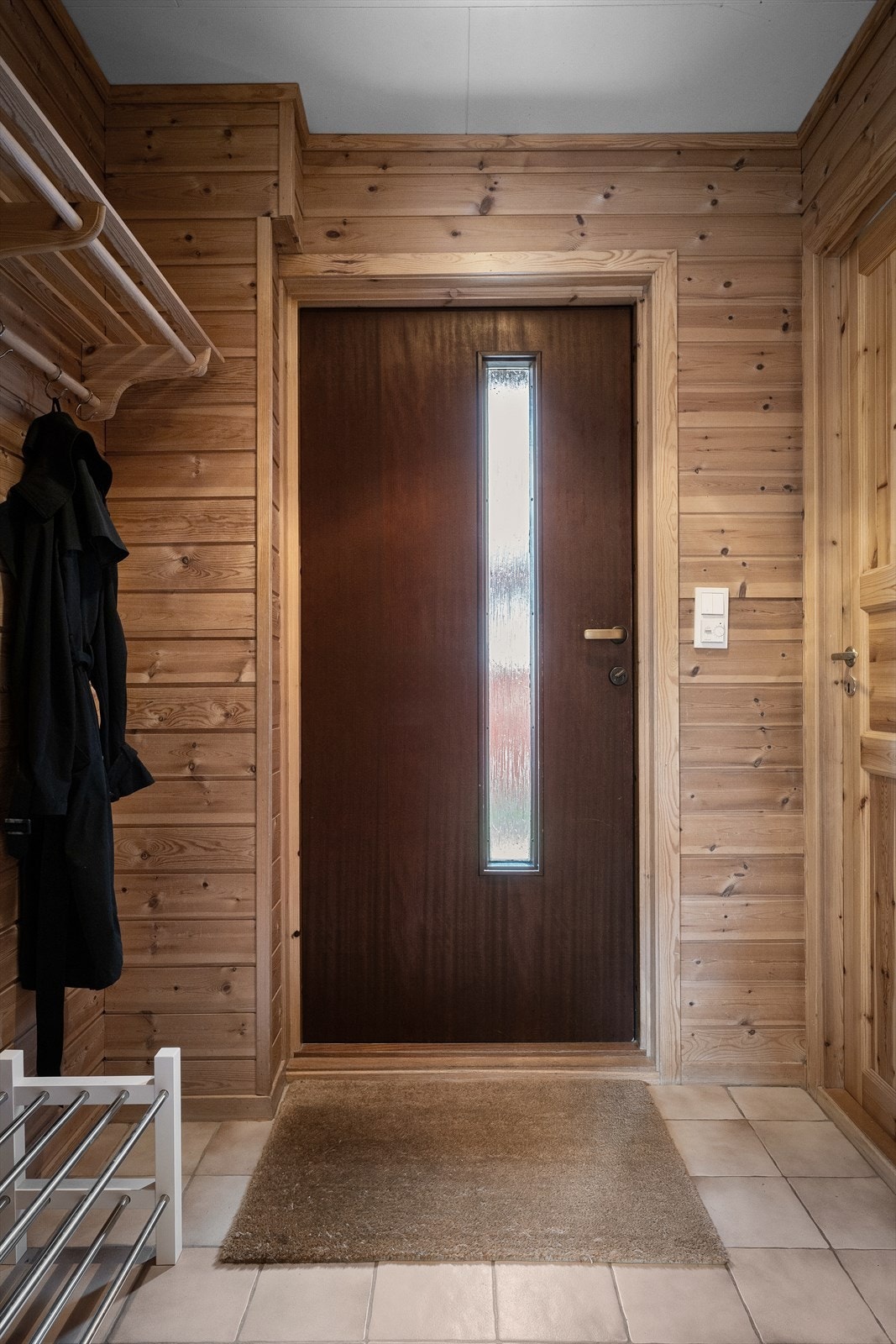 Entré med fliser for våte sko, og oppheng og hyller. Galleribilde