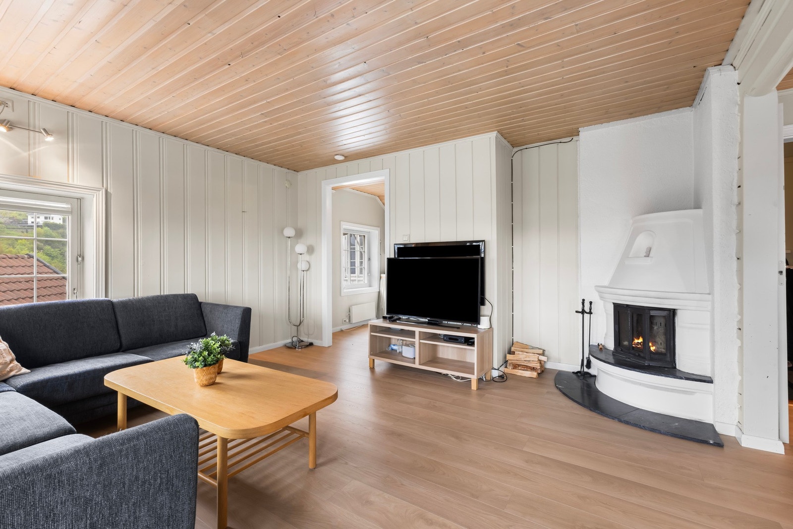 Stue med peisinnsats og lune overflater - et hyggelig oppholdsrom året rundt. Galleribilde