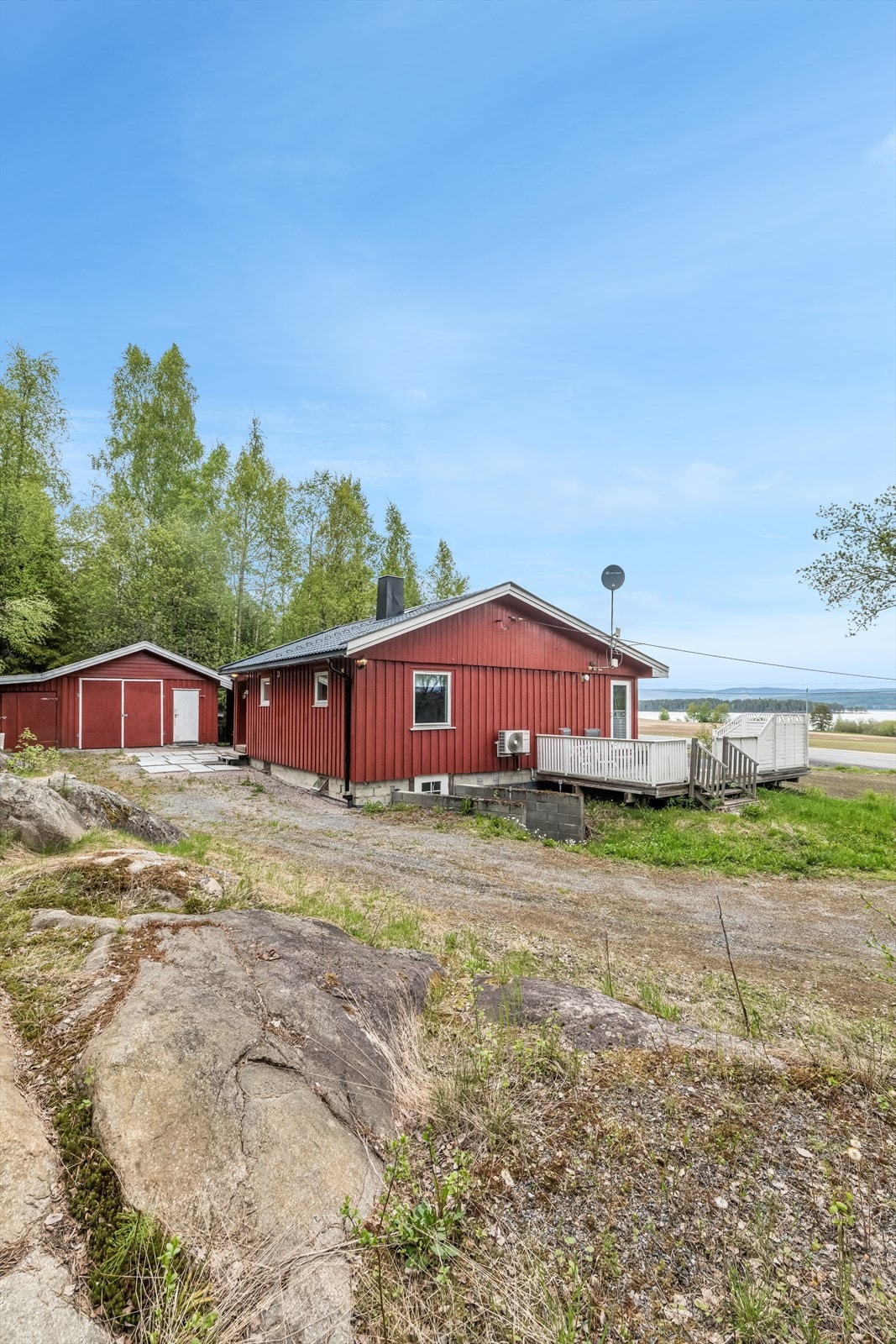 Tomten er terrassert med gruset gårdsplass og fjell i bakkant. Galleribilde