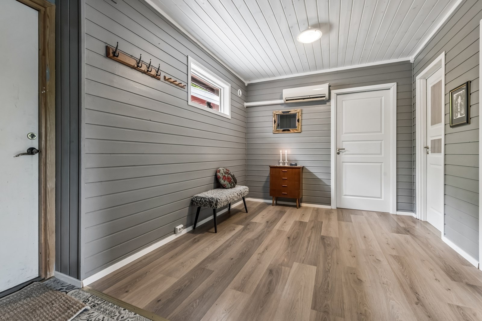 Innbydende entré med laminatgulv og malte panelvegger. Galleribilde