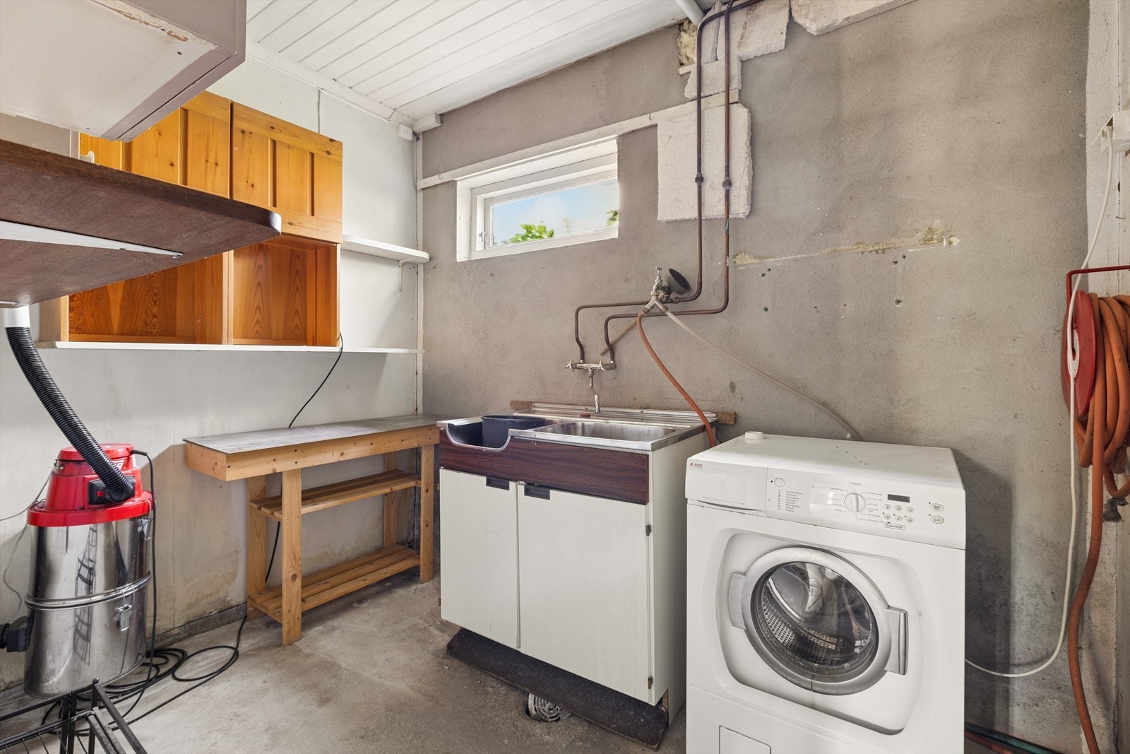 Praktisk separat vaskerom i underetasjen med betonggulv og opplegg for vaskemaskin. Behov for renovering. (Ikke omsøkt) Galleribilde