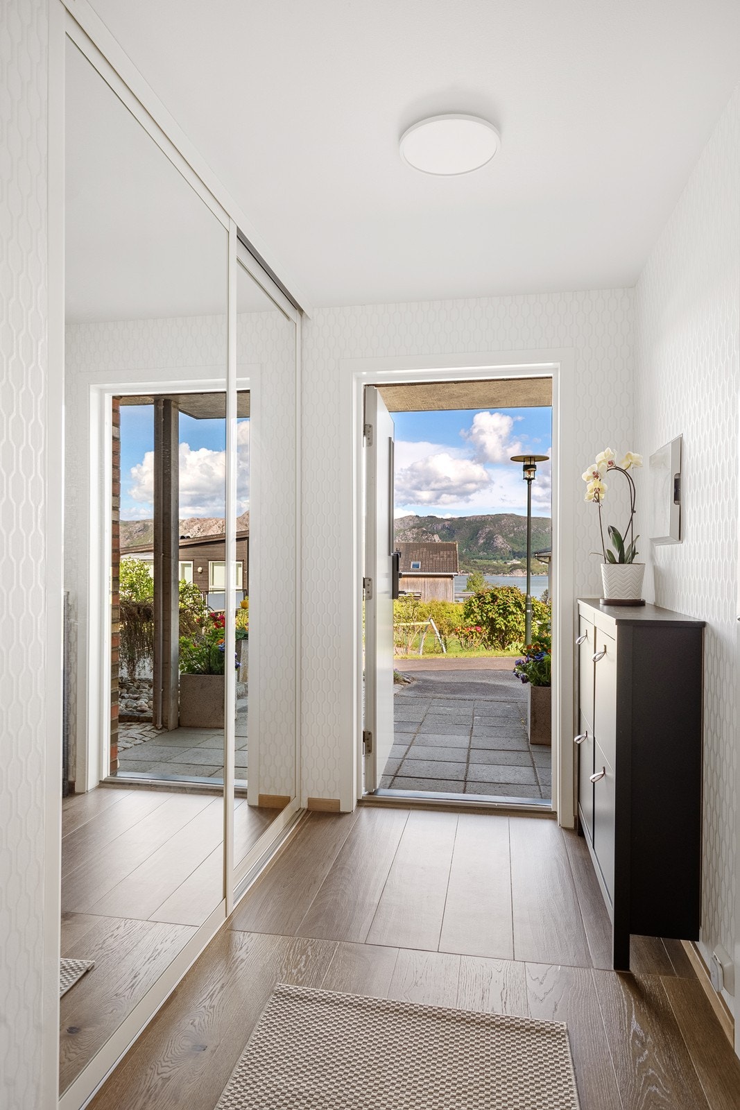 Velkommen inn. Det er god oppbevaringsplass av yttertøy i praktisk skyvedørsgarderobe med speildører Galleribilde
