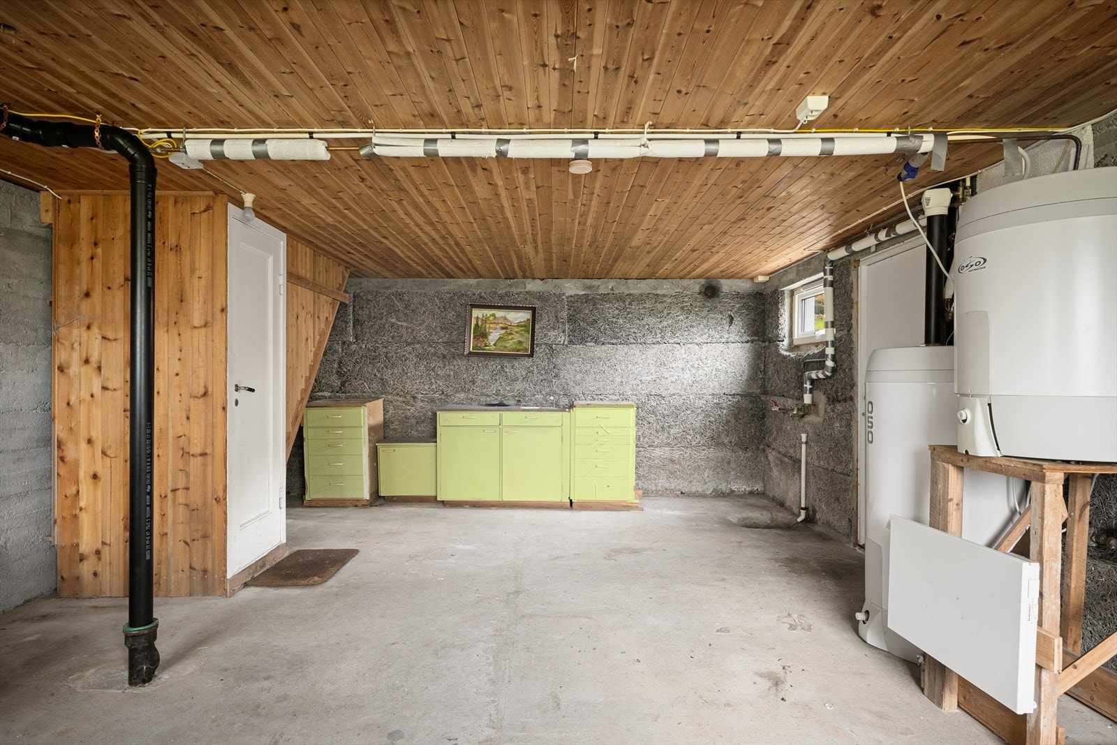Kjellerrom med betonggulv og vegger. Her er det opplegg for vaskemaskin. Galleribilde