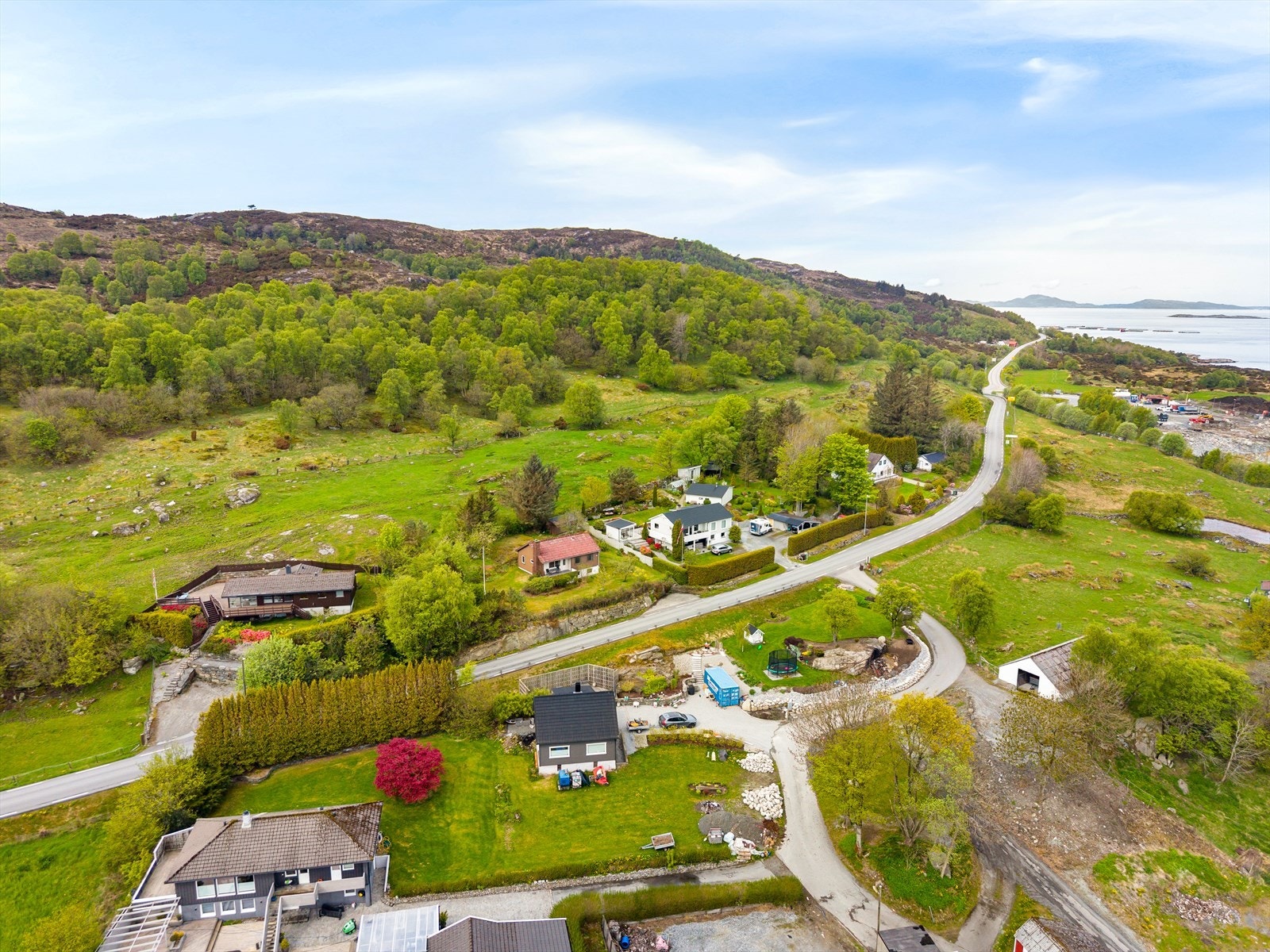 Eiendommen sett fra luften, med nærhet til både sjø og grønne turområder. Galleribilde