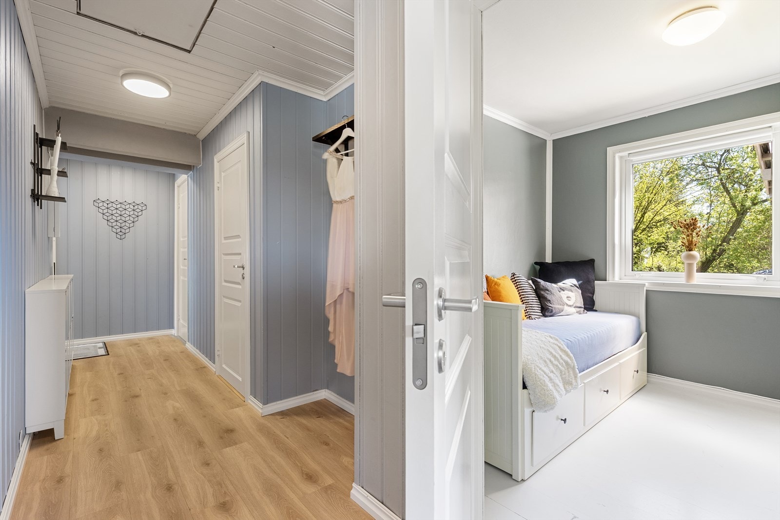 Pen entré/gang med laminatgulv og panelplater på vegger, malt i 2021 som del av en større oppgradering av hele etasjen. Galleribilde