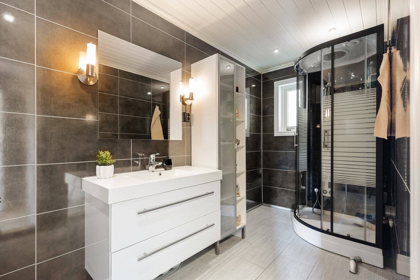 Badet i hovedetasjen ble utvidet og oppgradert i 2011. Her er det flislagt gulv med varmekabler, veggmontert toalett og dusjkabinett. Galleribilde