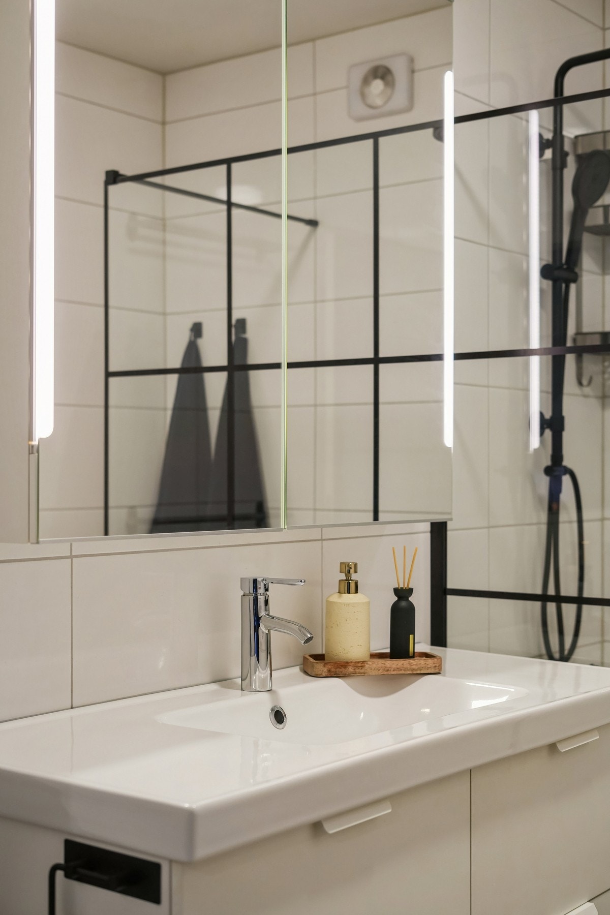 Badet har innredning med skuffefronter og hvit helstøpt servant. Det er skapspeil med belysning over servant. Galleribilde