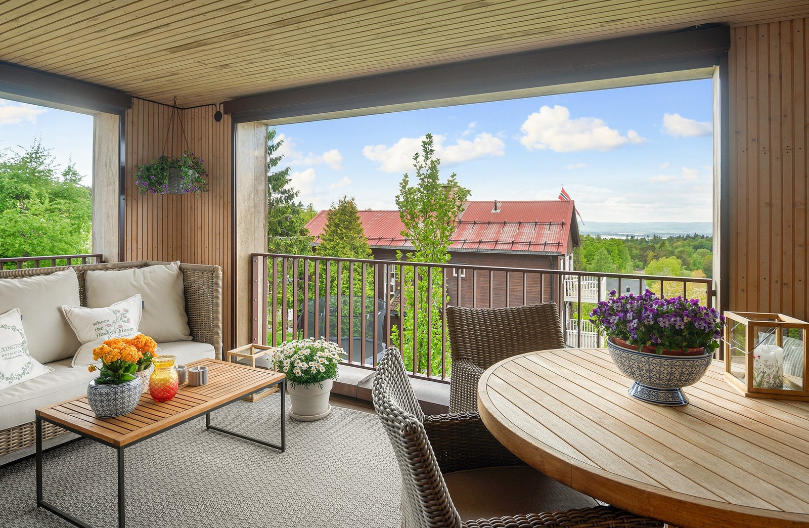 Overbygget balkong på ca. 10 kvm med med utsikt, rekkverk i stål og treplatting på gulvet. Galleribilde