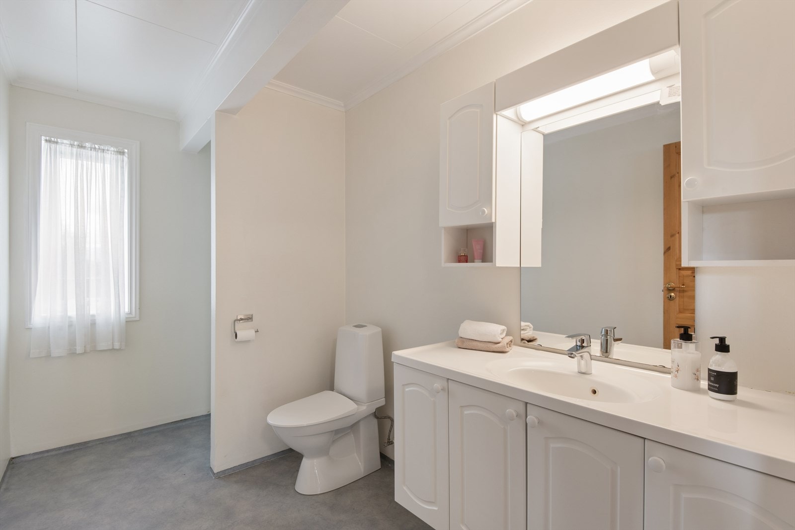 Badet i 1.etasje har innredning med heldekkende vask, toalett og dusjsone. Badet er eldre, og har behov for renovering. Galleribilde