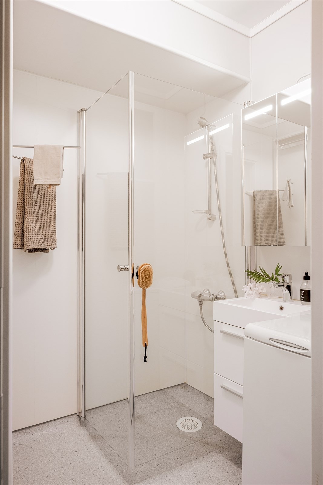 Badet er innredet med nyere veggplater, dusjvegger, servant med tilhørende møblement, sluk og gulvbelegg. Galleribilde