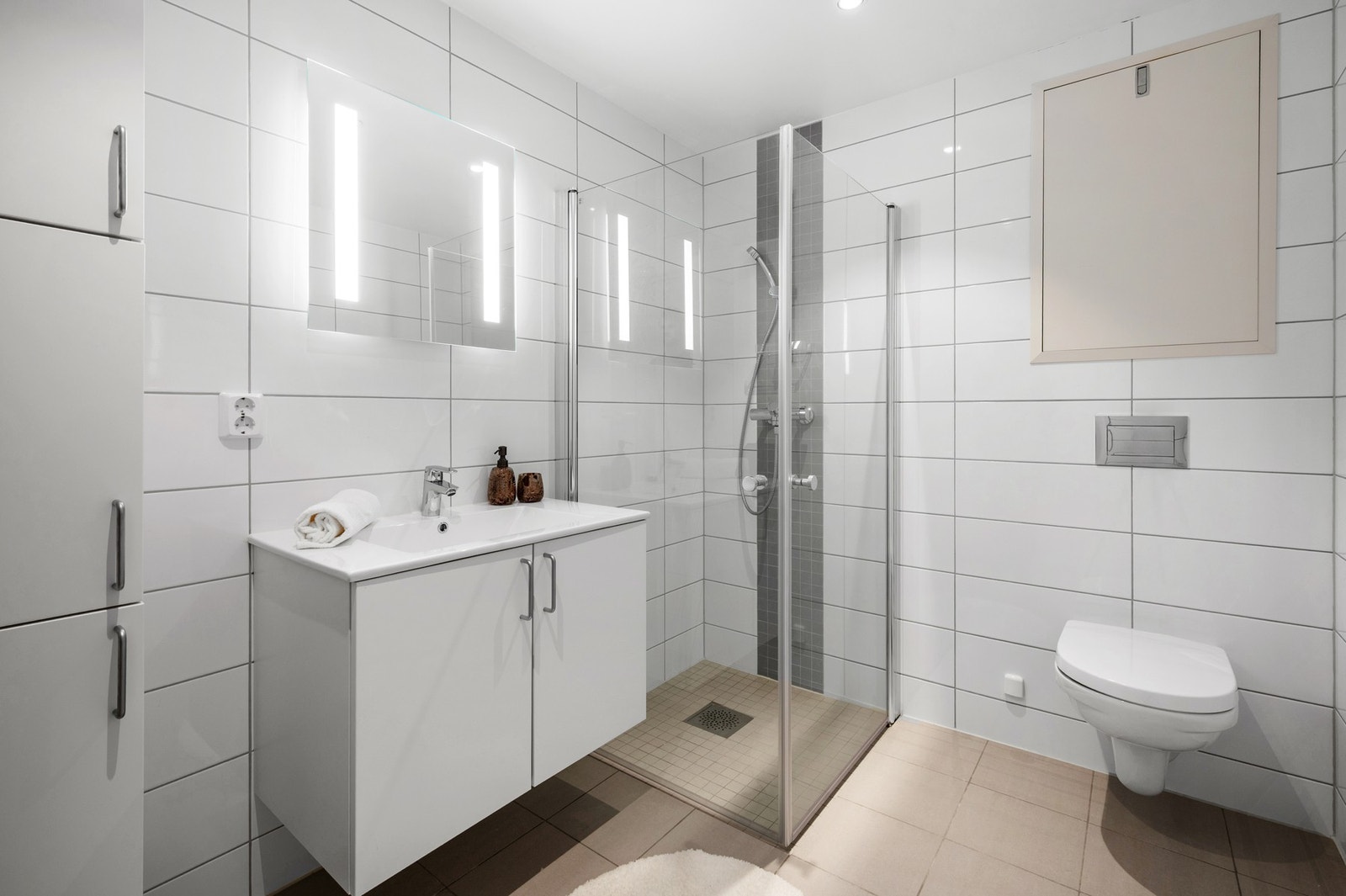 Romslig hovedbad på 5,3 kvm. Badet inneholder wc, servant med speil, dusjhjørne, skap og opplegg for vaskemaskin. Galleribilde