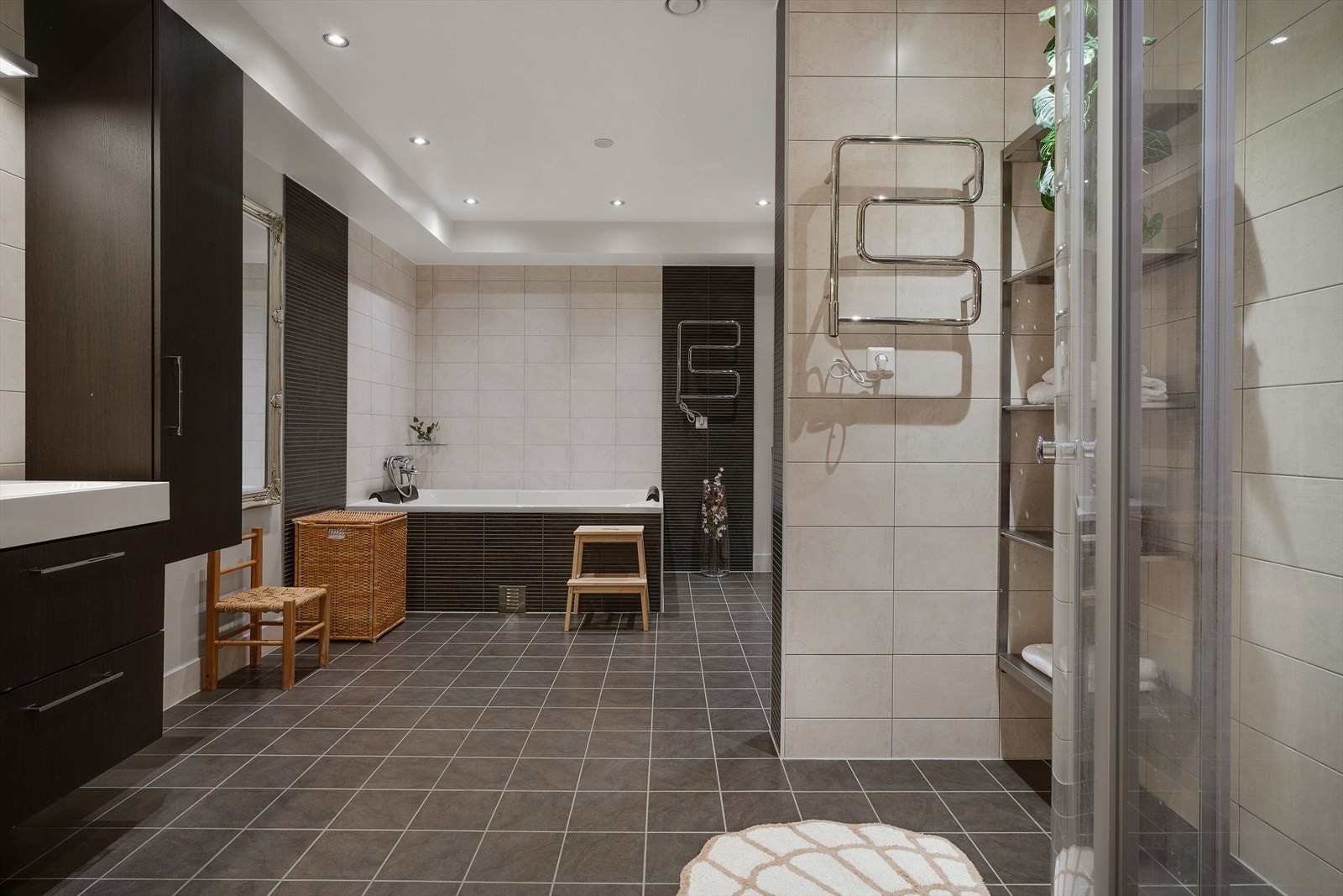 Hovedbadet i første etasje er svært romslig og utstyrt med både innfliset badekar og dusjhjørne. Gulvet har keramiske fliser med varmekabler. Galleribilde