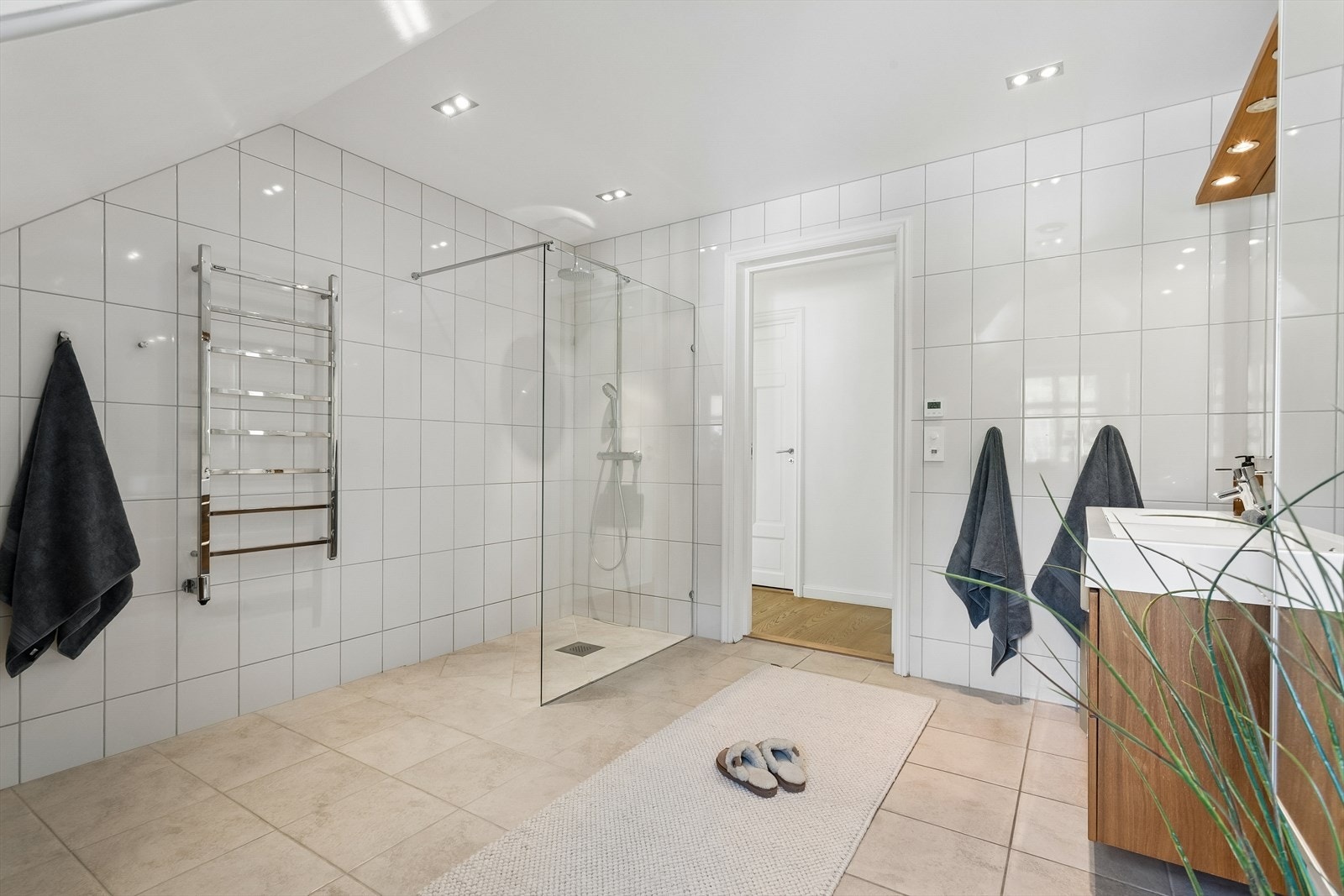 Badet er utstyrt med både dusj med glassdør og vegghengt toalett. I tillegg er det montert elektrisk håndkletørker Galleribilde