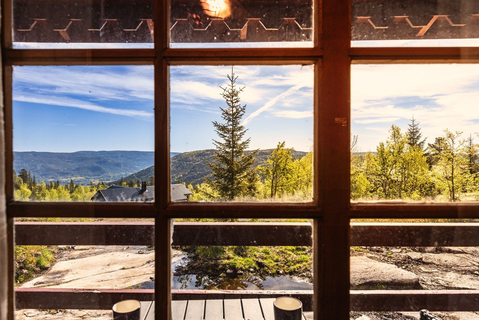 Vinduene med koblede glass fra byggeåret rammer inn utsikten mot det omkringliggende landskapet. Galleribilde