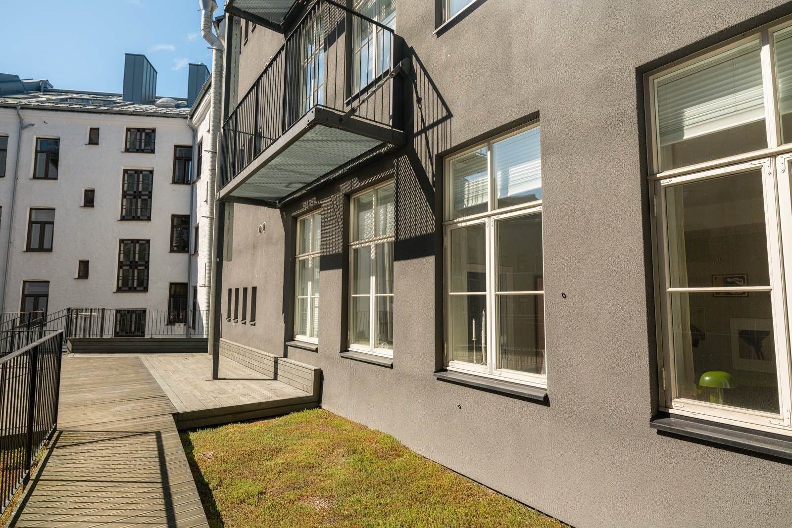 Flott terrasse med terrassebord og en liten plenflekk. Galleribilde