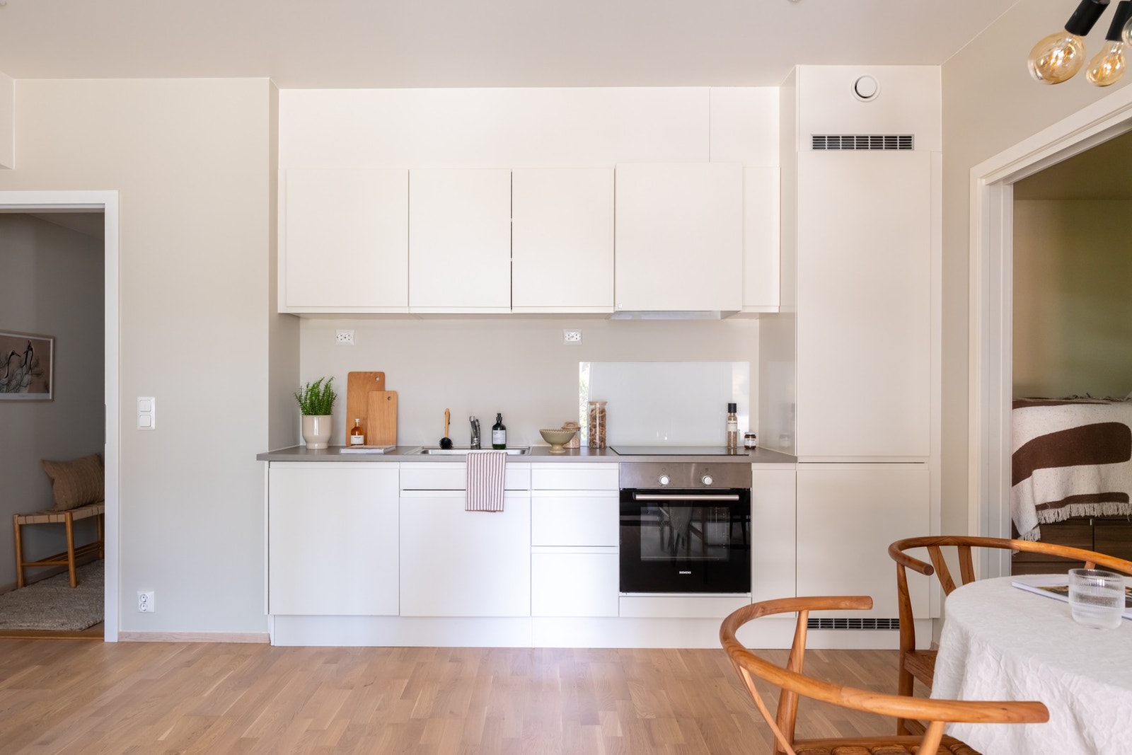 Lys, glatt innredning med laminat benkeplate og nedfelt oppvaskkum. Galleribilde