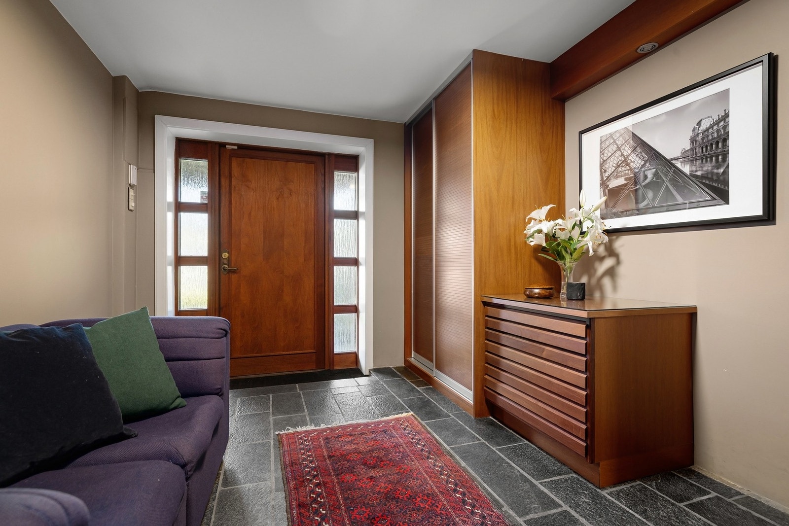 Hovedentré/hall, med flislagt gulv og garderobe innredning. Galleribilde