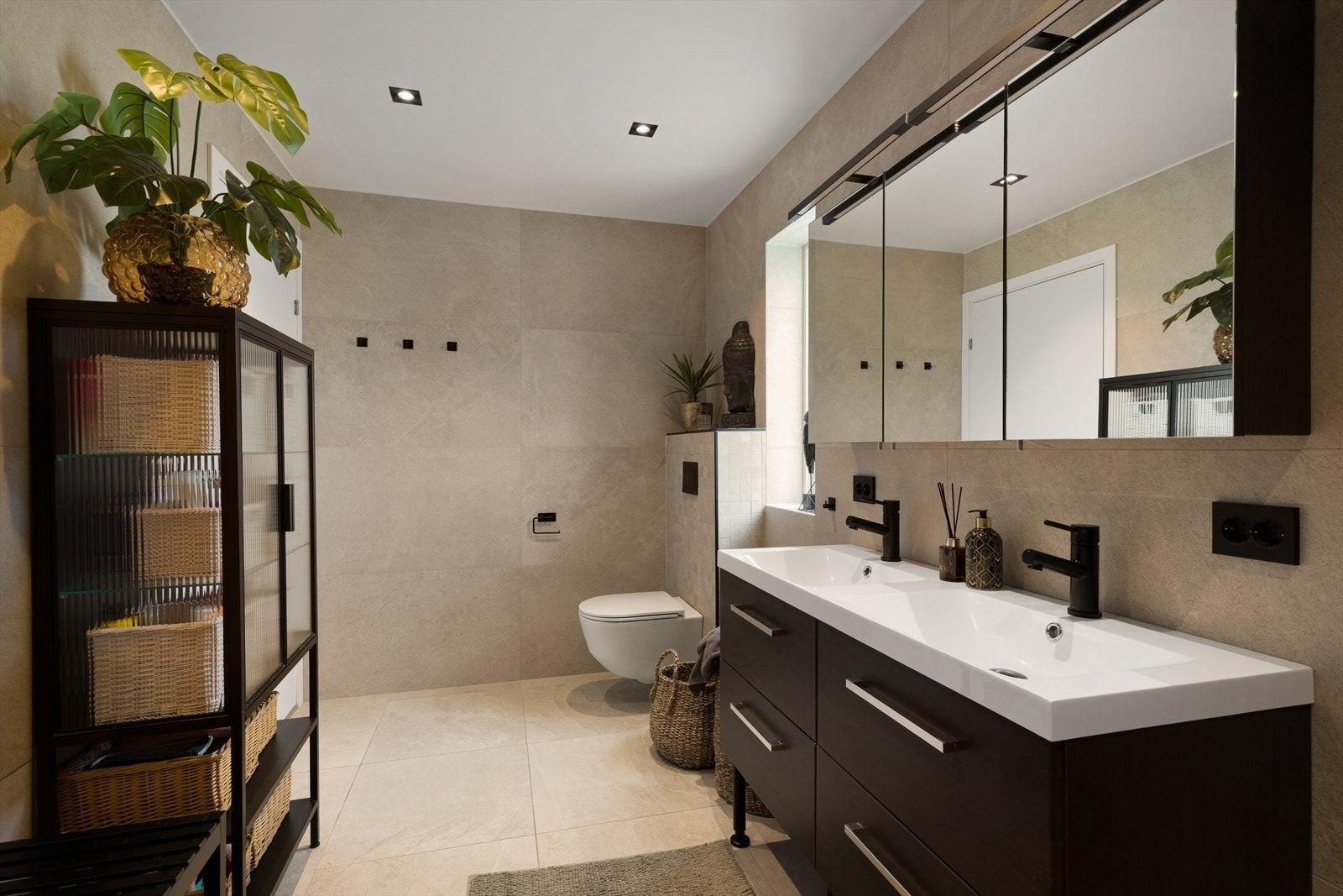Badet i underetasjen holder en moderne standard med helflisede overflater, sorte detaljer og varmekabler i gulvet. Galleribilde