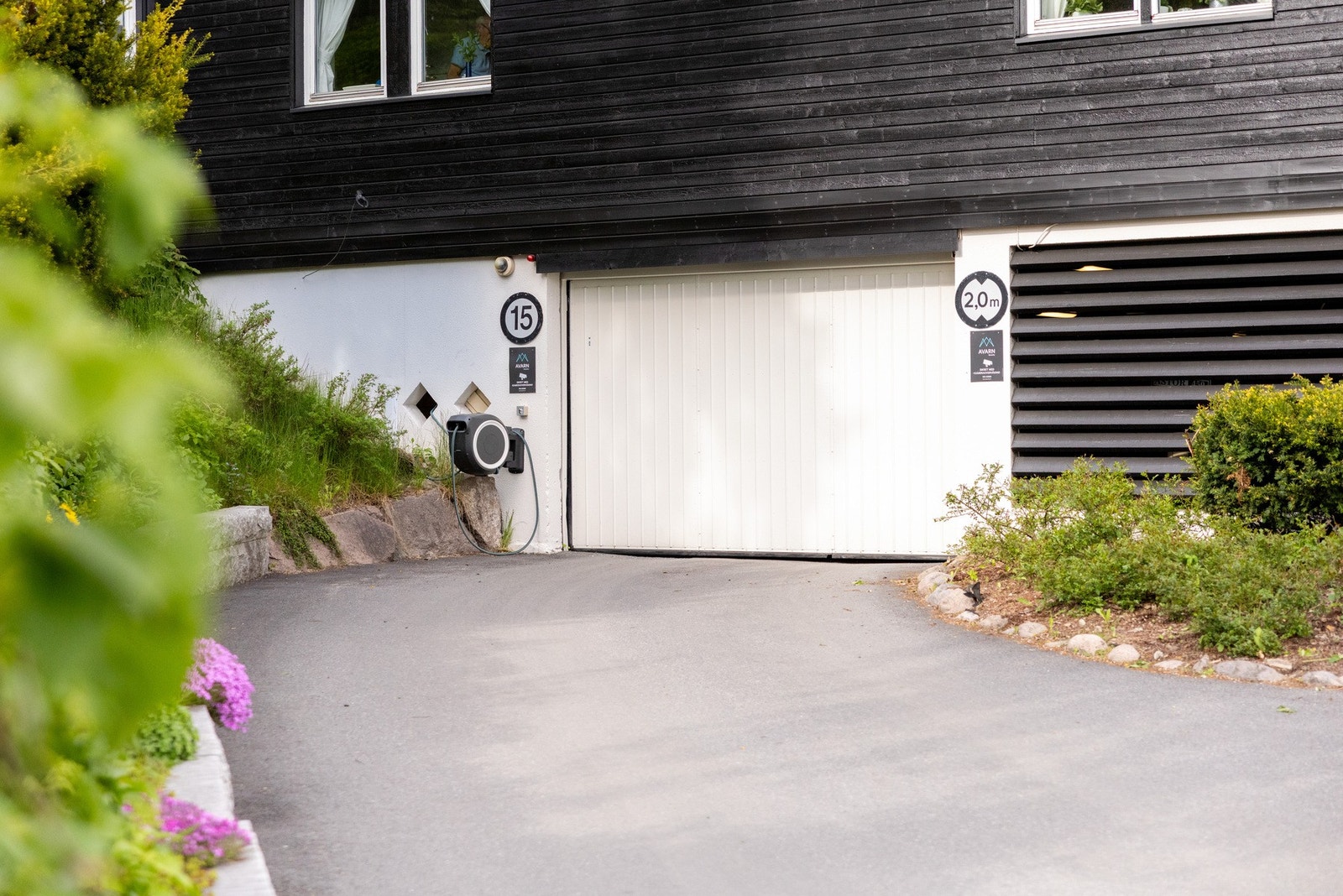 Innkjøring garasjen. Leiligheten disponerer 1 garasjeplass i felles anlegg med ladestasjon for elbil. Galleribilde