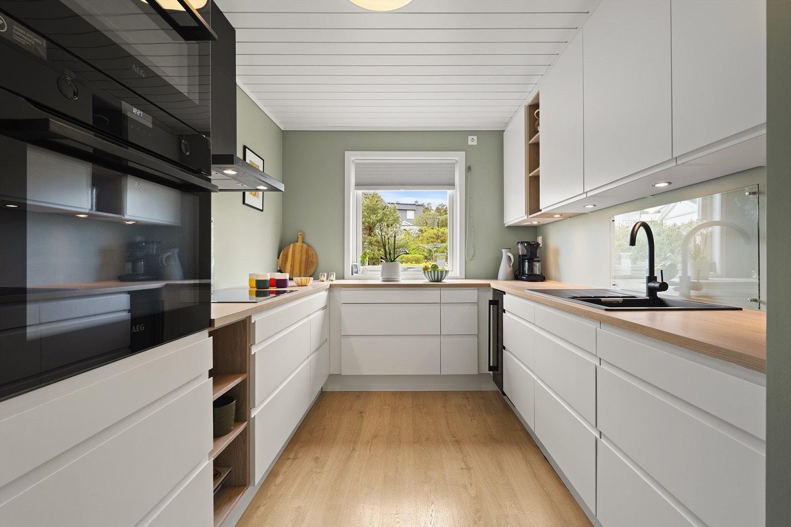 Kjøkkeninnredningen har glatte fronter og en slitesterk laminatbenkeplate. Galleribilde