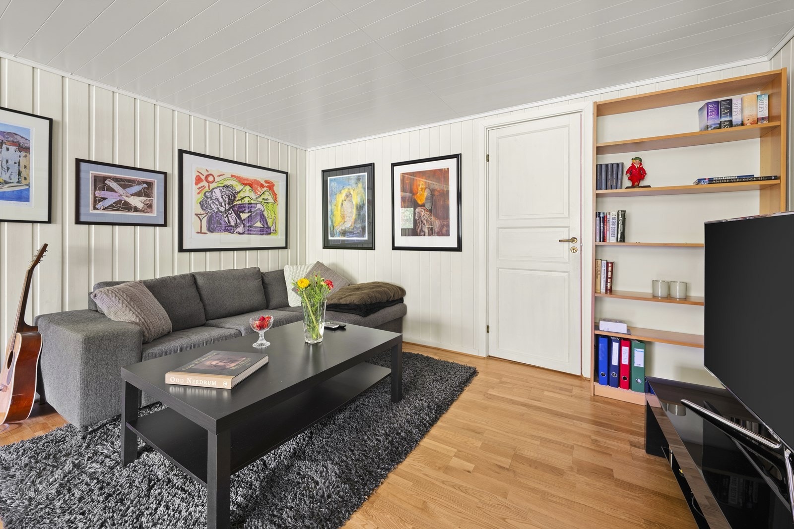 Malt panel på veggene gir en lys atmosfære i kjellerstuen. Galleribilde