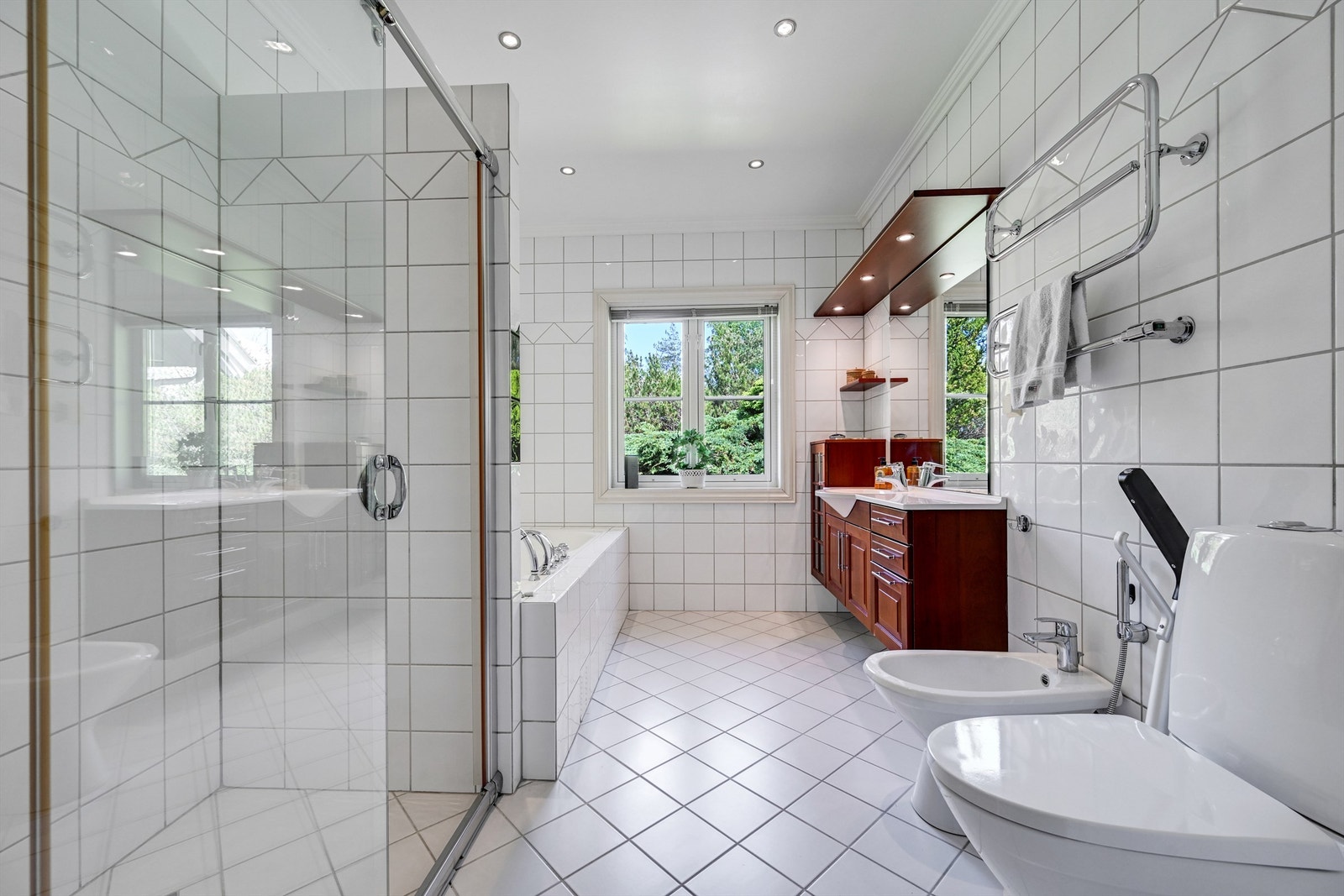 Badet har elektriske varmekabler i gulvet, dusjnisje med skyvedør i glass og bidé. Galleribilde