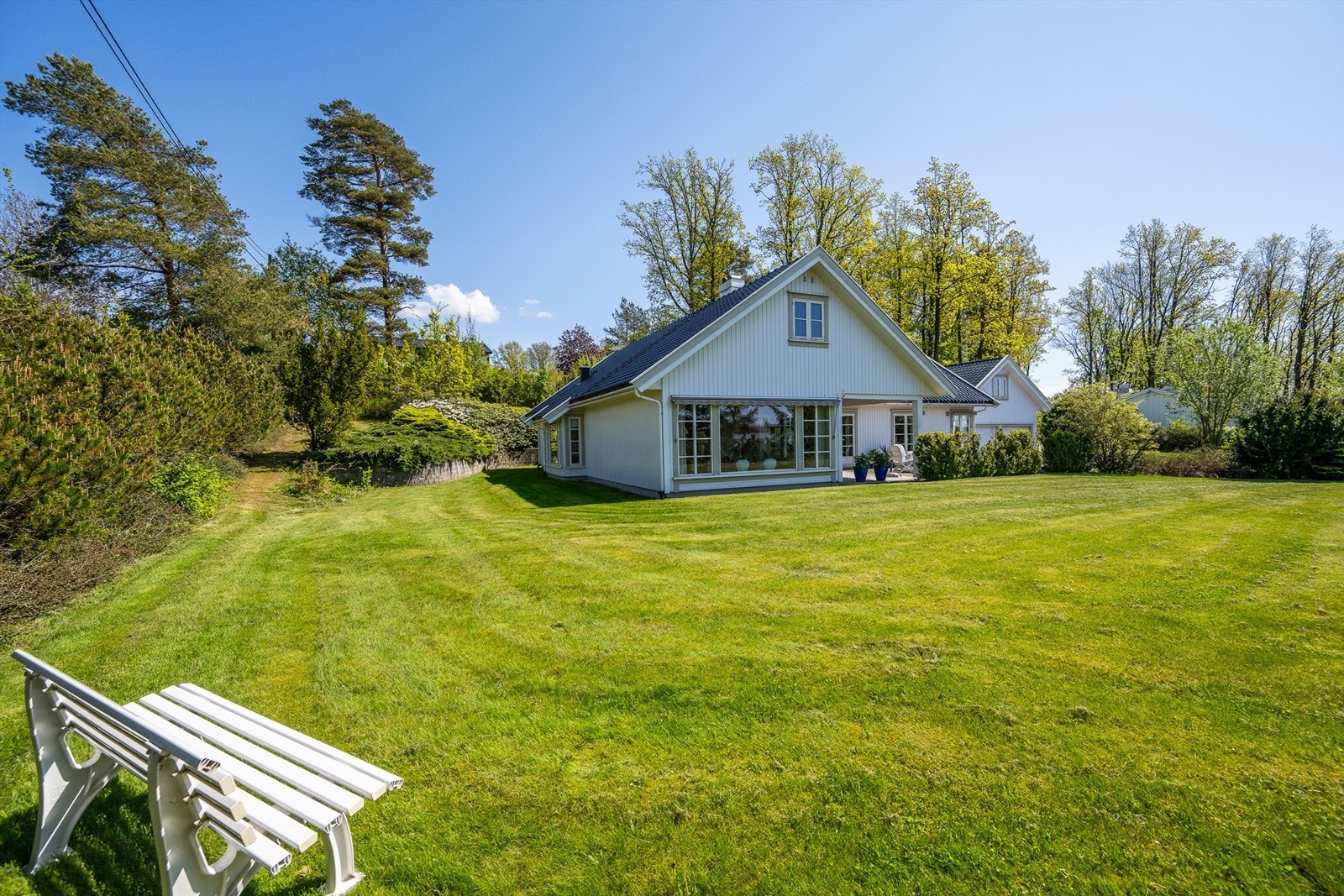Stor og solrik hage som omkranser boligen. Galleribilde