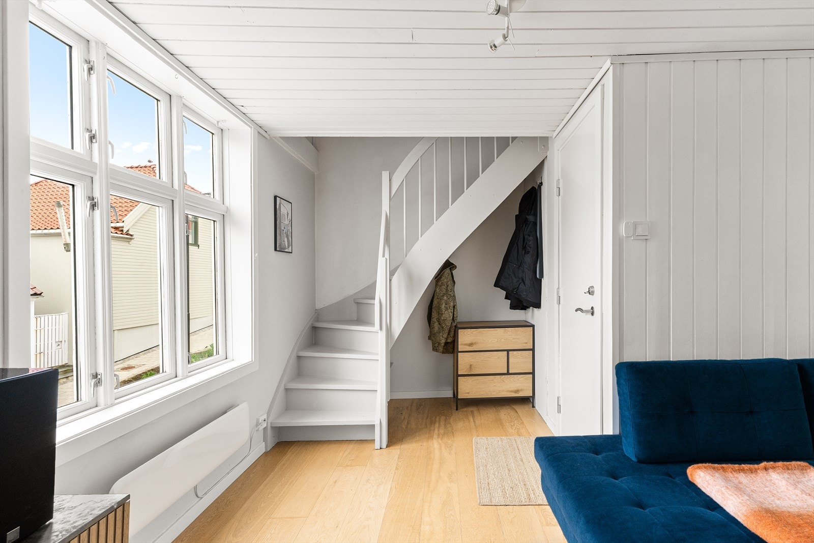 Plass til å henge fra deg yttertøy under trappen som går opp til de to rommene som brukes som soverom. Galleribilde