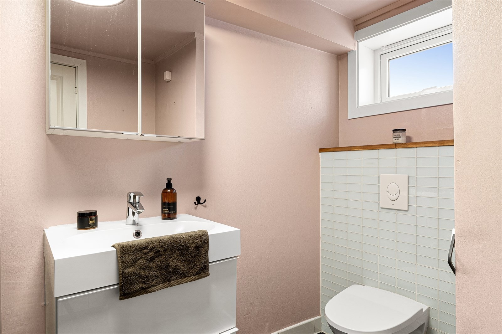 Badet har flislagt gulv med varmekabler, vegghengt toalett, dusjkabinett og opplegg for vaskemaskin. Galleribilde