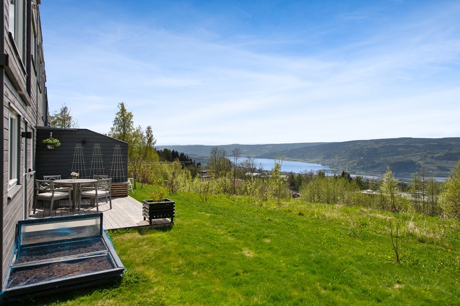 Terrasse på vestsiden. Hage opparbeidet med plen. Levegg mot nabo Galleribilde
