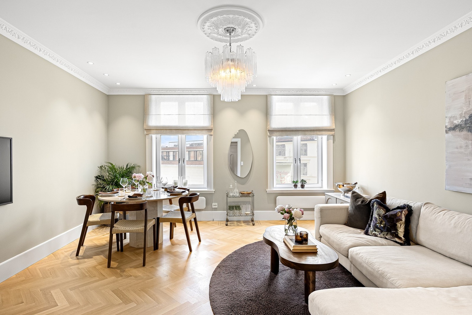 Stuen har flotte klassiske detaljer som stukkatur og rosett, kombinert med elegant fiskebensparkett som er gjennomgående for resten av boligen. Galleribilde