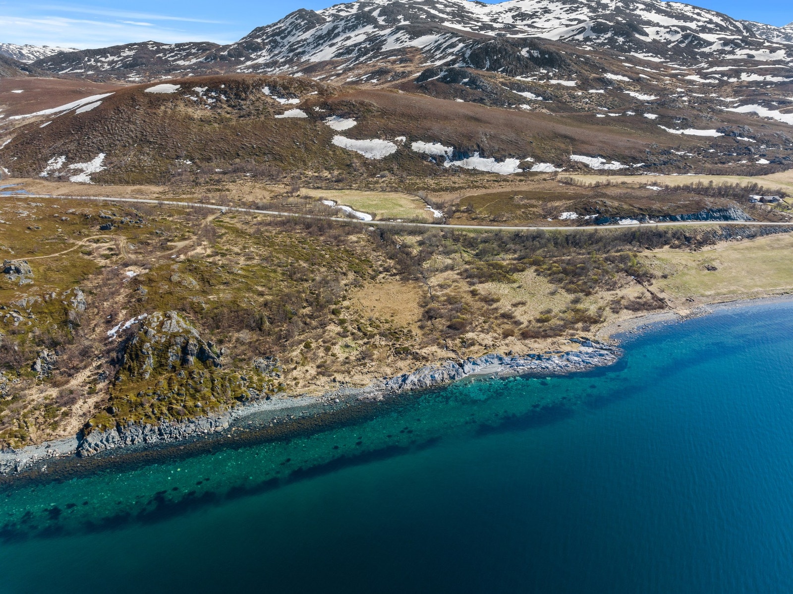 Klart vann og rullesteinsstrand langs eiendommens kystlinje. Galleribilde
