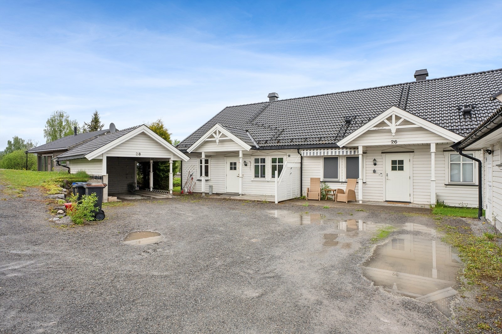 Eiendommen har en gruset gårdsplass og egen carport med tilhørende bod. Galleribilde