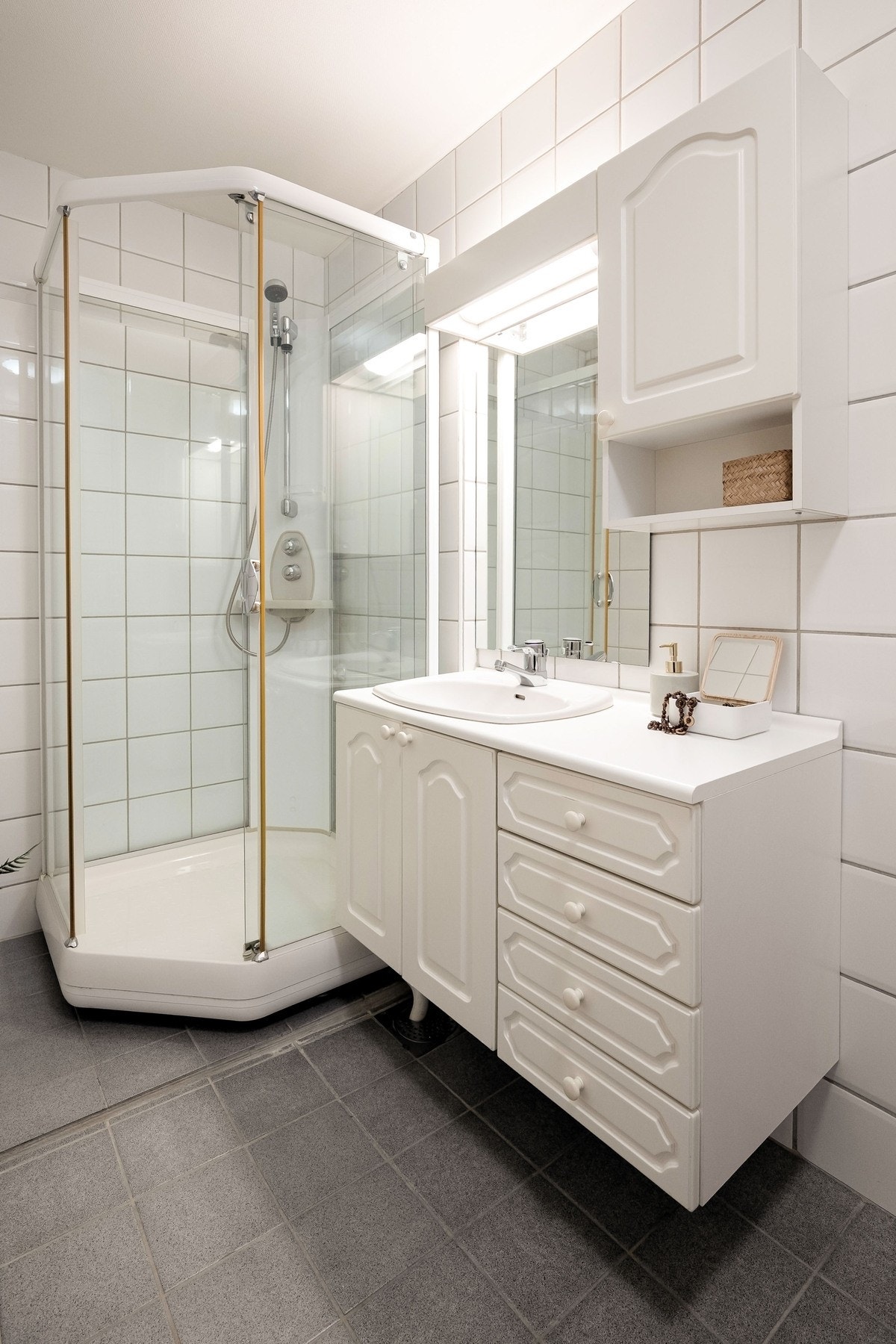 Badet er innredet med dusjkabinett og innredning med servant og godt med oppbevaringsplass. Galleribilde
