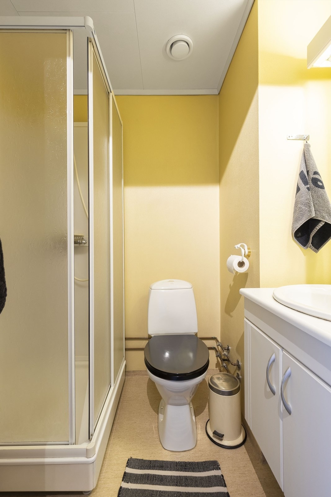 Bad med varmekabler i gulv. Dusjkabinett, wc og servantinnredning. Galleribilde