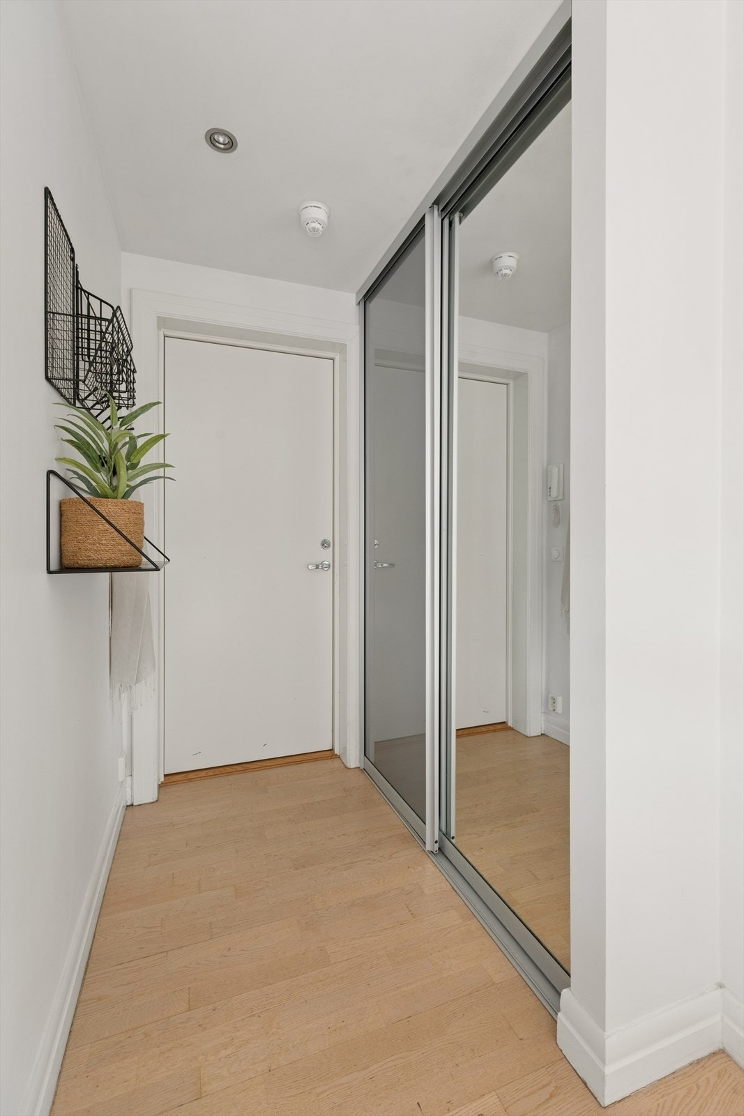 Innbydende entré med innfelt belysning i himling og praktisk skyvedørsgarderobe med speilfronter. Galleribilde