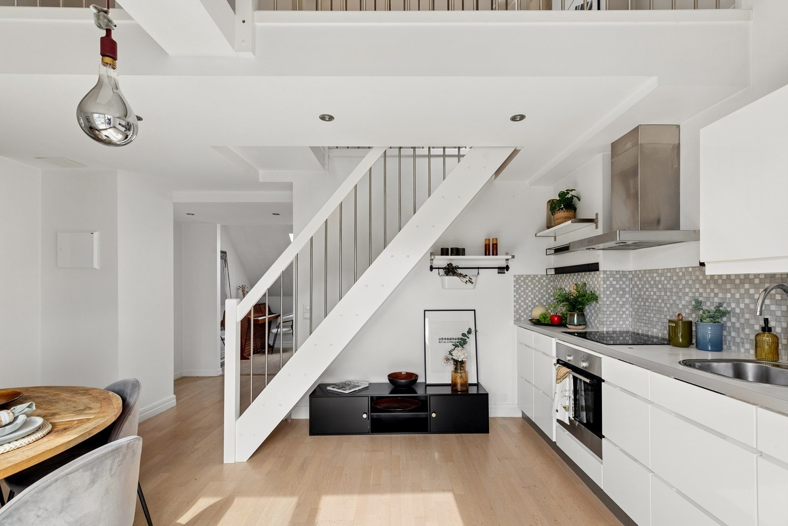 Den åpne trappen i tre med stålspiler binder de to nivåene sammen på en elegant måte. Galleribilde