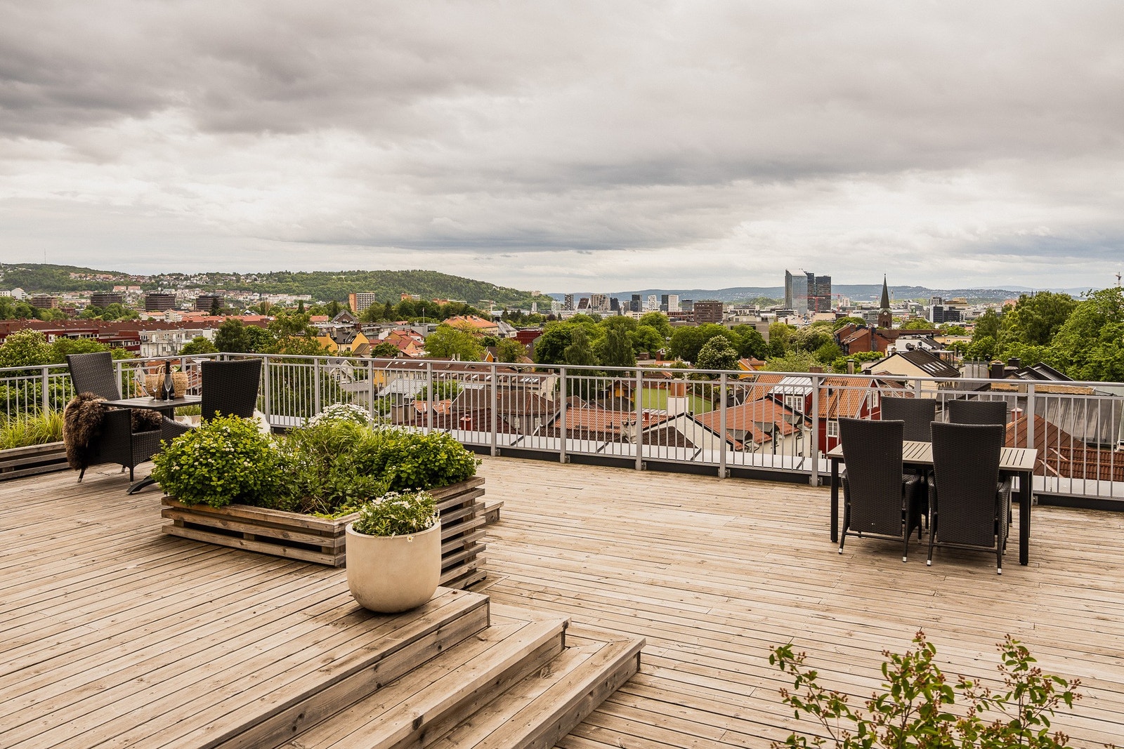 Stor, felles takterrasse med flere sittegrupper og flott utsikt over byen. Galleribilde