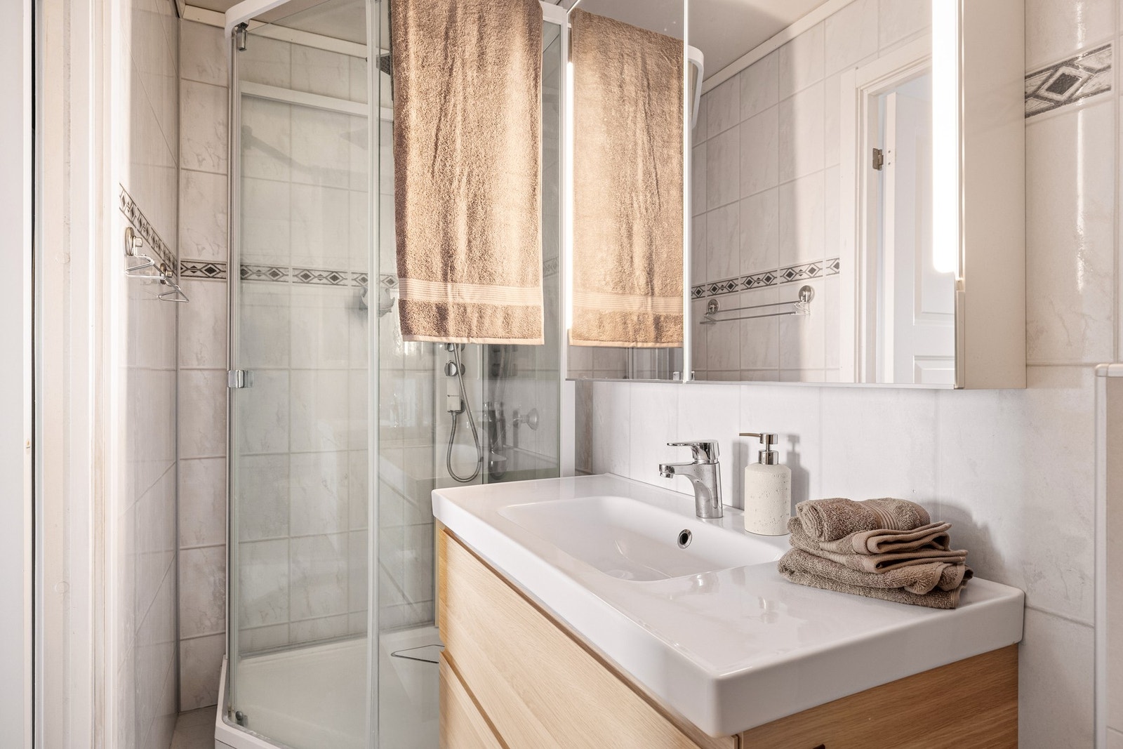 Badet er 3,2 kvm og har dusj, toalett og servant med oppbevaring Galleribilde