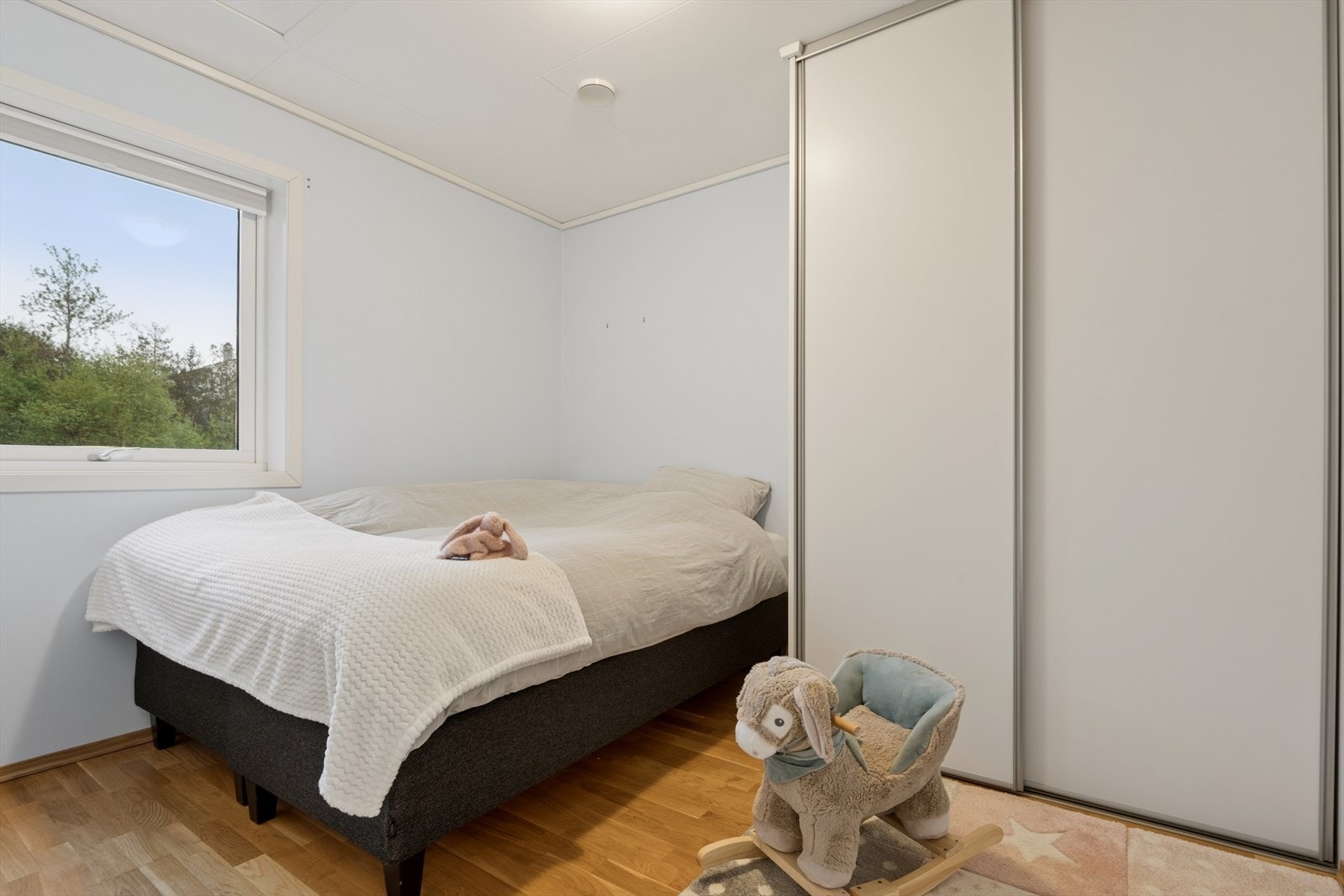 Et av soverommene, innredet med skyvedørsgarderobe og luke til loft med god lagringsplass. Galleribilde