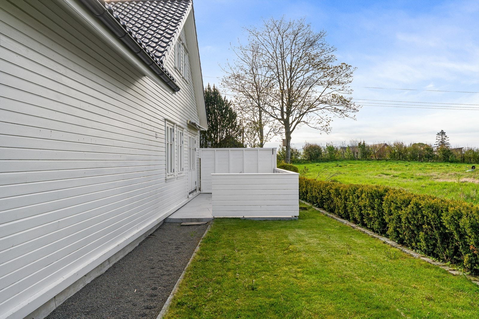 Eiendommen har en eiet tomt på ca. 541 m² med gruset gårdsplass og plen. Galleribilde