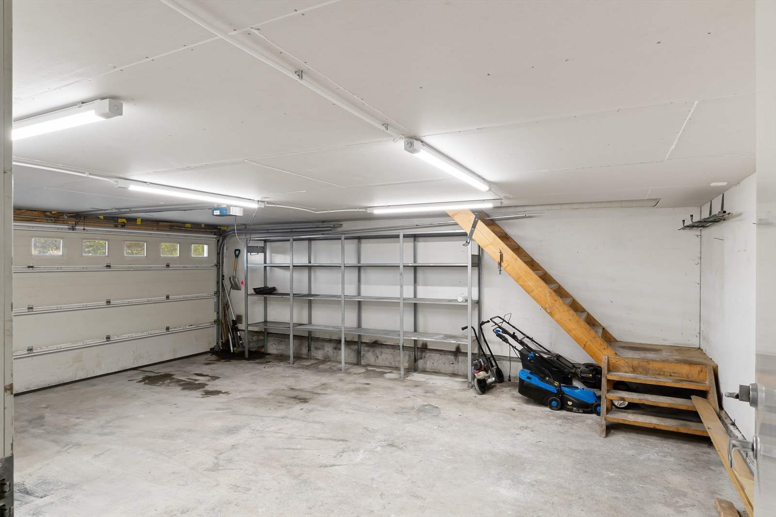 Garasje med elektrisk leddport og trapp opp til garasjeloftet. Galleribilde