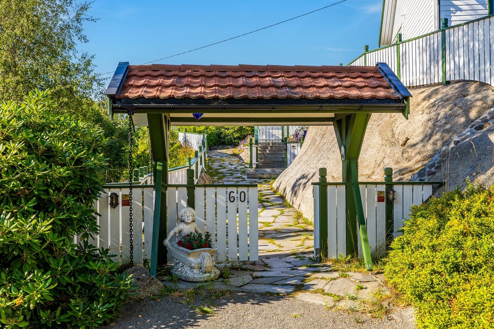 Fra gårdsplassen er det en port og en gangsti med skifer opp til selve hytta. Galleribilde