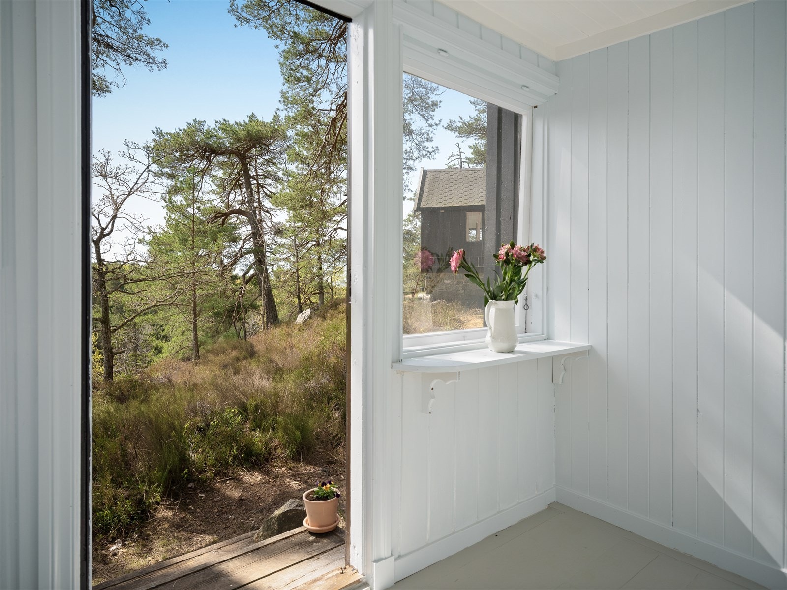Vinduene rammer inn den grønne naturen og slipper lyset inn. Galleribilde